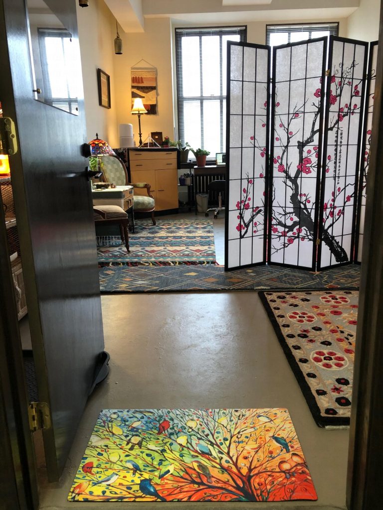 The office doorway, looking past a cherry-blossom folding screen toward tall windows