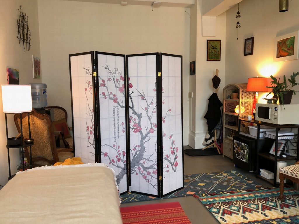 The bodywork table in the foreground, with the cherry-blossom screen and seating area behind