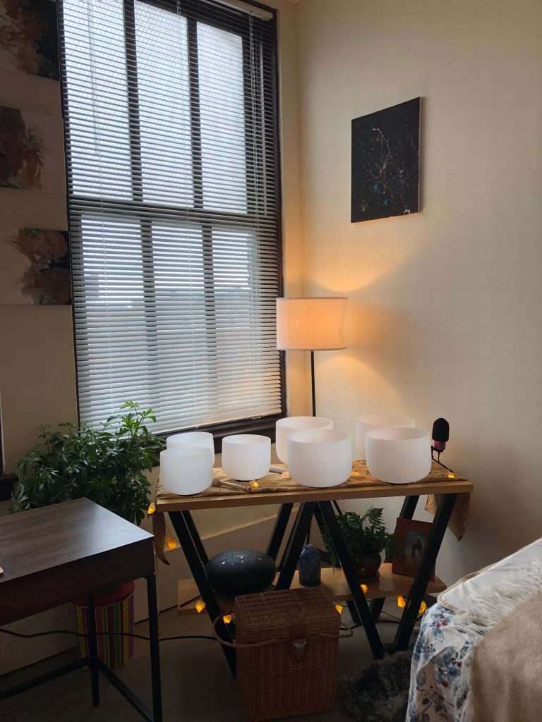 A closer view of the crystal singing bowls, with plants and a warm lamp